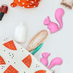 Lifestyle shot of the cute pink squirrel vibrator on a bed, highlighting its discreet design. 