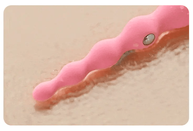 Close-up texture view of the pink Fizzglow Current Anal Vibrator showing smooth body-safe silicone graduated beads and integrated microcurrent contact pin